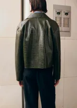 Chaqueta verde oscuro de poliuretano con acabado efecto cocodrilo, corte recto, bolsillos con solapa en el frente y cierre de botones.