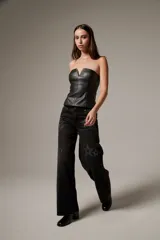 Pantalón jean de corte recto y tiro bajo, color negro gastado, con detalles de apliques de strass formando diseños de estrellas, soles y flores.