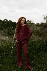 Pantalón de punto color bordó, de corte ancho y diseño holgado con costuras horizontales decorativas con efecto ondulado.