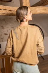 Sweater negro de algodón con cuello redondo y detalle de lentejuelas brillantes en el hombro.