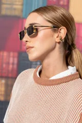 Chaleco de punto color beige con rayas verticales marrones y cuello redondo.