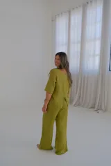 Pantalón de lino verde lima, de corte recto y tiro medio, con cinturón beige de soga incluido.