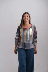 Sweter de punto con diseño abstracto en tonos terracota, azul petróleo, gris y blanco, con detalles de pinceladas doradas brillantes en el frente. Presenta cuello redondo, mangas tres cuartos y un corte holgado.
