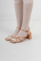 Sandalias de tacón bajo con diseño de tiras finas cruzadas en el empeine y cierre de hebilla en el tobillo. Presentan una puntera cuadrada y acabado con textura efecto reptil en tonos metalizados.