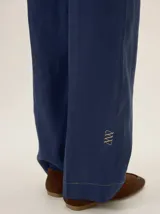 Pantalon de lino azul marino de corte recto y diseño clásico, con cintura elastizada y sutil bordado en el isotipo de la marca en la parte inferior de la pierna.