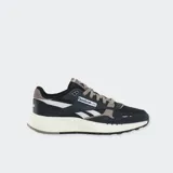 Championes Reebok modelo Classic Leather 2400, color negro con detalles en gris y blanco, entresuela beige y cordones grises.