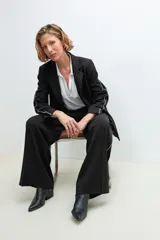 Blazer negro con bordado en contraste a lo largo de las mangas.