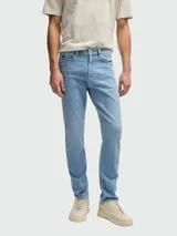 Jeans de corte slim fit en color azul claro con efecto lavado. Presenta cierre de botón y cremallera, cinco bolsillos clásicos y costuras reforzadas.