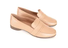 Mocasines de cuero color nude, con diseño clásico de calce fácil, costuras pespunteadas en la puntera y suela plana con leve tacón.