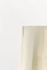 Falda midi de tiro medio color beige en tejido de viscosa con estampado jacquard y aplicación de encaje a tono en el bajo, con cierre lateral de cremallera oculta.