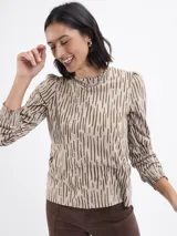 Remera de algodón con estampado de líneas verticales irregulares, cuello redondo y mangas largas con hombros abullonados y puños elásticos fruncidos.
