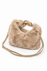 Cartera de mano de tejido peludo color marrón claro, con detalles en cuero sintético, asa superior con nudo y correa ajustable desmontable.