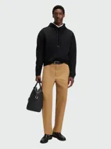 Buzo negro con capucha y cordones ajustables, corte holgado. Presenta un pequeño logo bordado en relieve en el pecho.