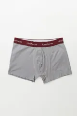 Boxer de algodón color gris claro, con elástico ancho de color bordó que lleva la inscripción "Uniform" en blanco.