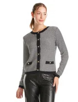 Cardigan de tejido tweed con diseño de pata de gallo en blanco y negro. Presenta cuello redondo, cierre frontal con botones metálicos dorados, mangas largas y dos bolsillos decorativos en la parte inferior con ribetes a contraste.