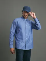 Camisa de vestir de corte clásico, color azul, con cuello italiano, cierre frontal de botones y bolsillo en el pecho.