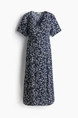 Vestido midi de viscosa azul marino con estampado floreado, escote en V, botonadura frontal y mangas cortas. Cuenta con elástico en la parte posterior de la cintura y una tira fina extraíble para atar debajo del busto, diseñado para usarse durante y después del embarazo.