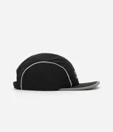 Gorra negra de microfibra, modelo 5 panel, con visera plana y logo estampado en blanco.
