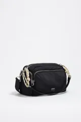 Bolso bandolera mediano de nylon negro con estructura blanda, detalles en piel, asa de hombro combinada de piel y cordón decorativo blanco y negro, cierre de cremallera y logo metálico de la marca.