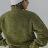 Buzo de sherpa color celeste con corte a la altura del pecho y bolsillo de nylon azul con logo estampado.
