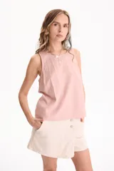 Short pollera de jean negro con spandex, diseño cruzado en el frente y cierre de botones metálicos en la parte superior.