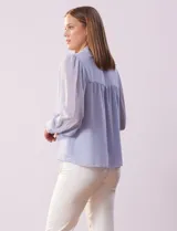 Camisa blanca de gasa marca Tahari, con cuello con solapa y abertura central con botones ocultos. Manga larga con puño y botones.