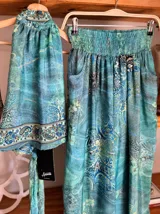 Conjunto de dos piezas color fucsia con estampado oriental en tonos rosa y blanco, compuesto por un top halter con lazo en la cintura y un pantalón palazzo de cintura alta con elástico.