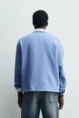 Sudadera azul con corte relaxed fit, cuello redondo y mangas largas con puños de rib, confeccionada en tejido con mezcla de algodón y acabado afelpado en el interior.
