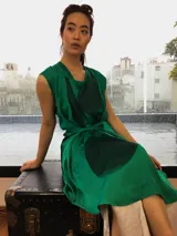 Vestido verde esmeralda con estampado abstracto en negro, corte suelto y largo midi. Presenta un lazo a la cintura para ajustar y mangas cortas.