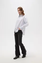 Camisa de algodón a rayas verticales, con cuello camisero, cierre frontal de botones y detalle de strass aplicado en la parte superior delantera.