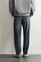 Jeans de corte slim cropped confeccionados en denim de algodón rígido con efecto lavado. Presentan tiro medio, cierre frontal con cremallera y botón, y diseño clásico de cinco bolsillos.
