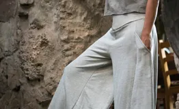 Pantalón palazzo gris melange de rústico de algodón, con tiro alto, bolsillos laterales, elástico en la espalda y faja ancha en la cintura.