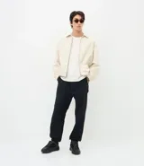 Pantalón jogger de sarga color negro, con cintura elástica con cordón de ajuste, bolsillos laterales y traseros, y puños elásticos en los tobillos.