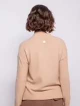 Sweater de punto tramado color rosa, de cuello alto y manga larga.