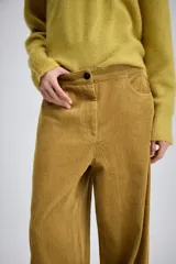 Pantalón de tiro medio confeccionado en tejido de pana, con diseño de pierna ancha, bolsillos delanteros y traseros, y cierre frontal con cremallera y botón.