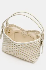 Bolso tipo saca de tamaño mini, color blanco off-white, con cuerpo de diseño trenzado, asa corta superior y cierre con cremallera metálica.