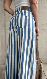 Jean estilo wide leg con diseño rayado en color celeste y blanco, de tiro alto y corte ancho en las piernas.