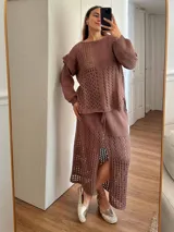 Pollera midi color crudo, tejida en hilo de algodón con calados horizontales. Tiene silueta recta, abertura frontal, elástico en la cintura y tiras regulables.