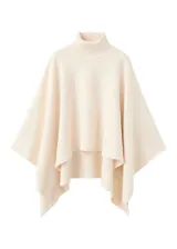 Poncho de tejido de punto color marfil, con cuello alto vuelto y diseño amplio con aberturas para los brazos.