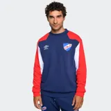 Buzo de entrenamiento Umbro, color azul marino, con diseño de bloques de color en hombros y mangas (rojo y blanco). Presenta el logo de Umbro y el escudo del Club Nacional de Football en el pecho.