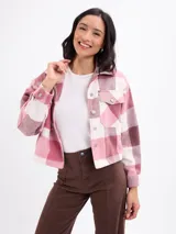 Sobrecamisa de corte cropped con diseño a cuadros en tonos rosa y beige. Presenta cuello clásico, cierre frontal con botones metálicos, mangas largas con puños abotonados y dos bolsillos frontales con solapa.