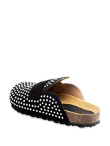 Sueco tipo mule de gamuza negra con apliques de strass plateados en toda la superficie. Cuenta con una banda frontal estilo mocasín, plantilla de corcho y suela de goma dentada.