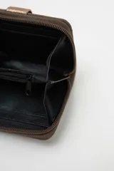 Billetera compacta de gamuza color beige con detalle de solapa central en cuero sintético marrón oscuro y cierre perimetral.