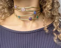 Gargantilla artesanal con cuatro hilos de bronce y alpaca, adornada con piedras de diferentes colores y formas.