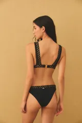 Conjunto de bikini color verde azulado con diseño de cortes láser decorativos en los bordes del corpiño y la bombacha. El corpiño es de estilo triangular con tirantes anchos y la bombacha es de corte clásico.