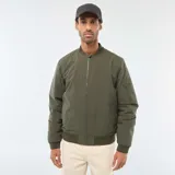 Campera estilo bomber color verde militar, con cierre frontal, cuello, puños y ruedo de tejido elástico acanalado. Presenta un bolsillo con cierre en la manga izquierda.