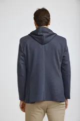 Blazer sport color gris claro con capucha integrada y cordones ajustables. Presenta solapas clásicas, cierre frontal con botones y bolsillos laterales de parche.