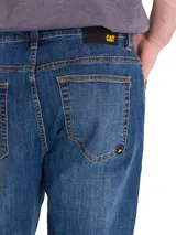 Jeans de denim azul con calce slim, diseño clásico de cinco bolsillos, cierre de cremallera y botón, y costuras en contraste.