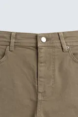 Pantalón de corte recto confeccionado en tejido de algodón con elasticidad. Presenta diseño de cinco bolsillos, cierre frontal con cremallera y botón.