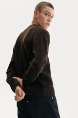 Buzo de punto suave con cuello en V, manga larga y terminaciones acanaladas en puños y cintura. Presenta un corte regular fit clásico.